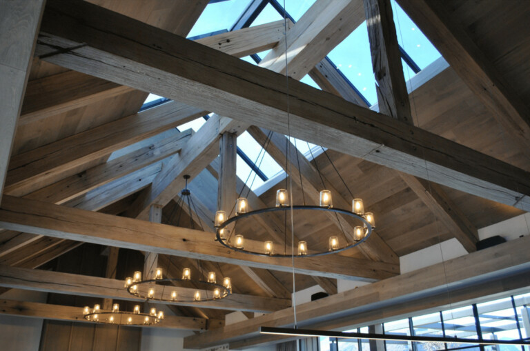 The ceiling of a building with wooden beams and chandeliers.